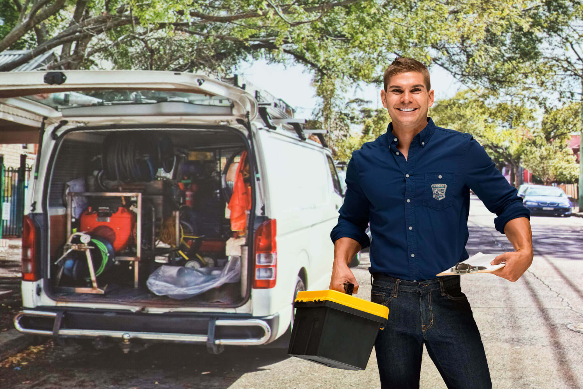 Plumber with tools in front of a van